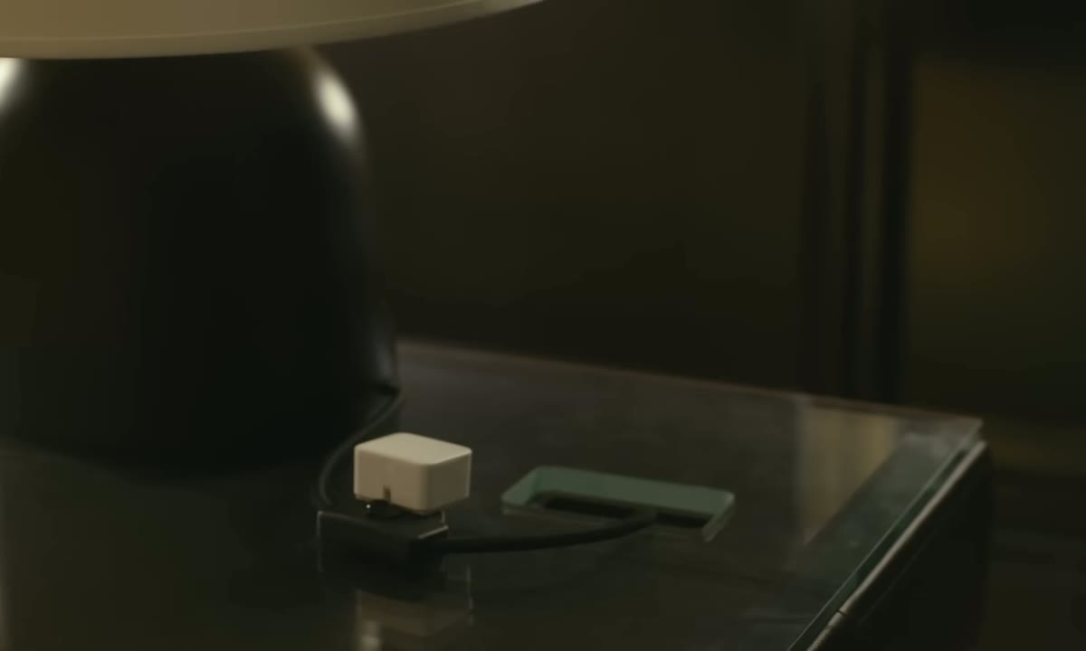 SwitchBot Bot pressing a hard-to-reach switch beside a lamp